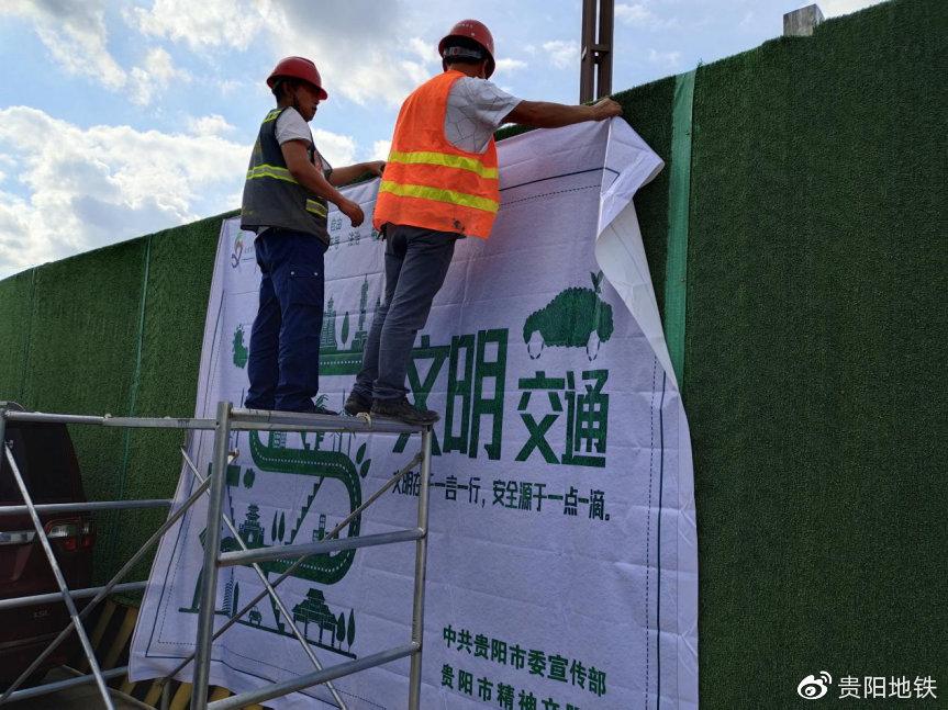 機電1標員工在七機路口站張貼文明宣傳畫